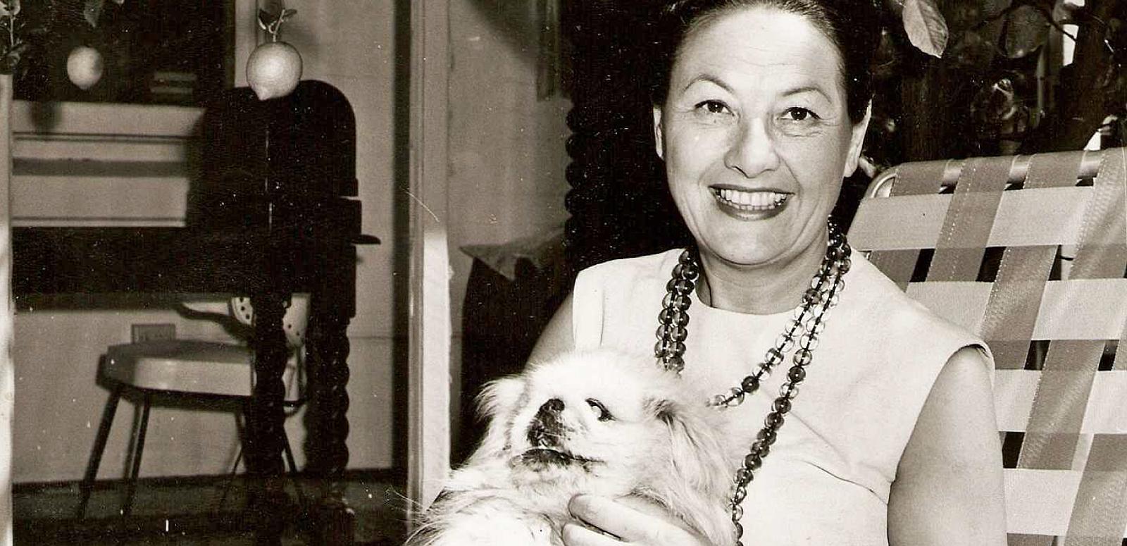 Binny Lum holding her dog, Ming. Circa 1960s.