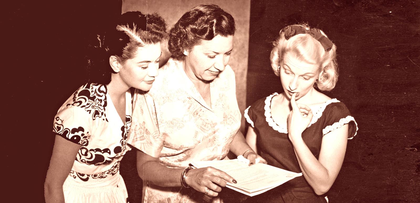 Grace Gibson (centre) looks over a radio serial script with two actresses. 