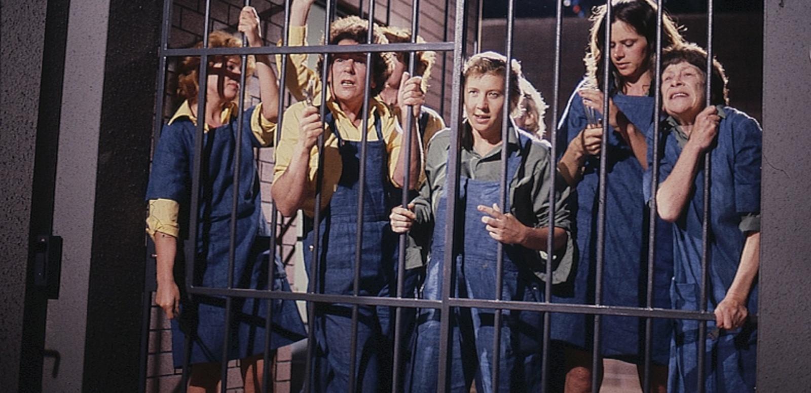 The immates of Wentworth Detention standing behind the bars during a riot. Frankie Doyle is the leader. Other main characters in this photo include Chrissy Latham and Lizzie Birdsworth.