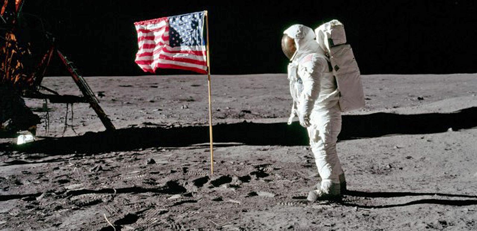 Astronaut on the moon standing near the American flag