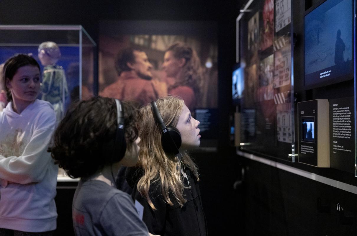 Two young girls looking at screen with headphones on