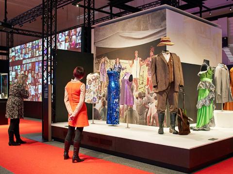 Two people viewing costumes on display at australians and hollywood exhibition