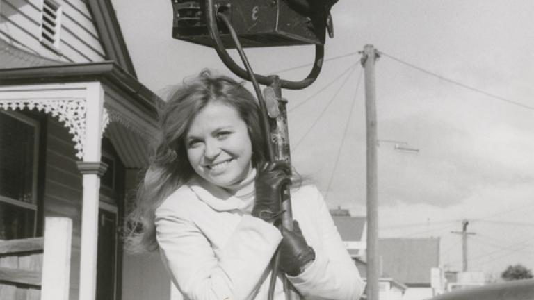 Jacki Weaver smiling with arms around a production light during the filming of Homicide