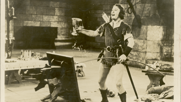Errol Flynn brandishes an oversized wine goblet