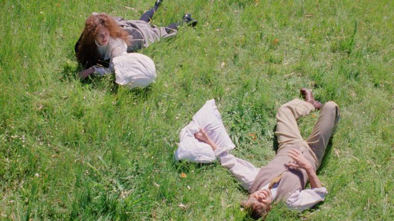 Judy Davis and Sam Neill lying in the grass in a still from My Brilliant Career