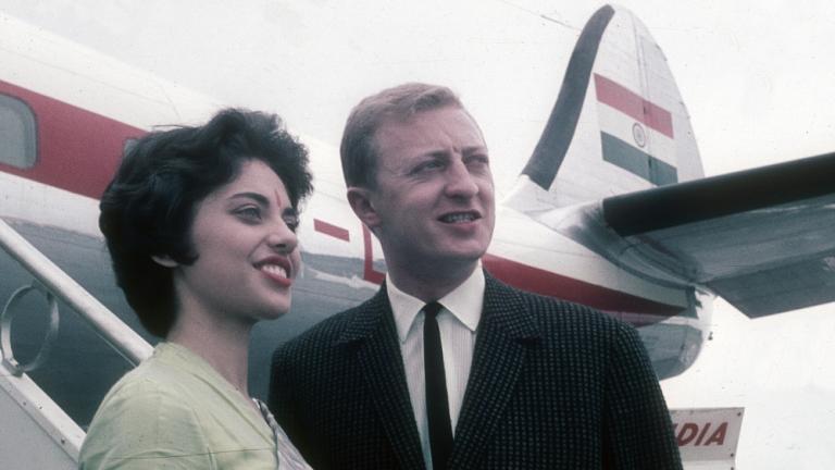 Graham Kennedy at the airport in India with an air hostess and a plane in the background