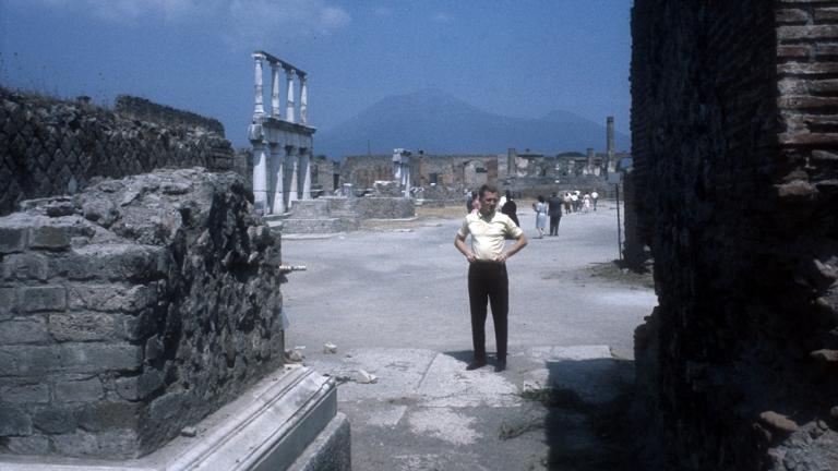 Graham Kennedy standing, hands on hips, exploring ancient ruins, Italy