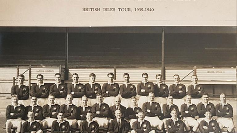 Image of a rugby team posing in three rows for a photograph 