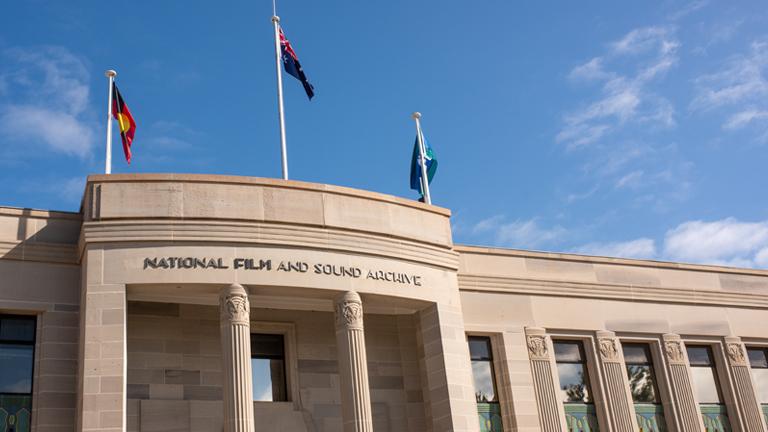 Top of NFSA art deco building with Aboriginal, Torres Strait Islander and Australian flags
