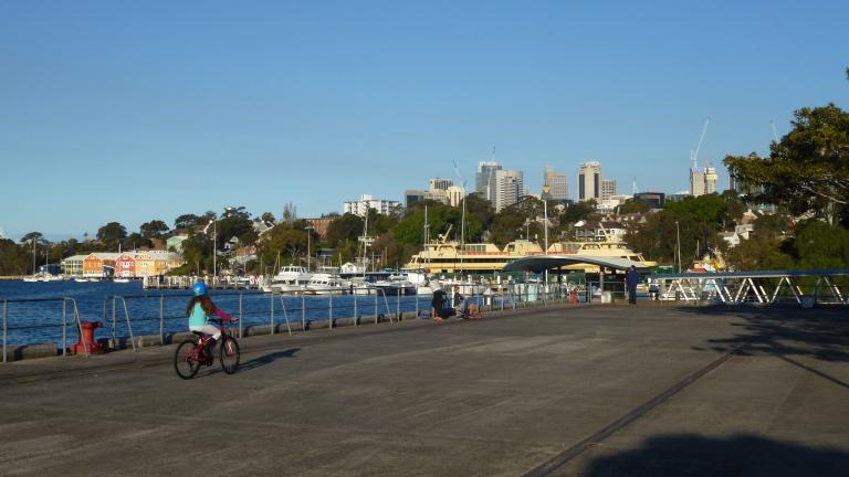 Child riding a bike along a warf on Sydney harbour