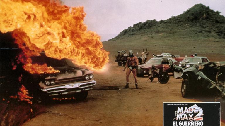 Mad Max 2 lobby card showing Humungus (Kjell Nilsson) next to a burning car.