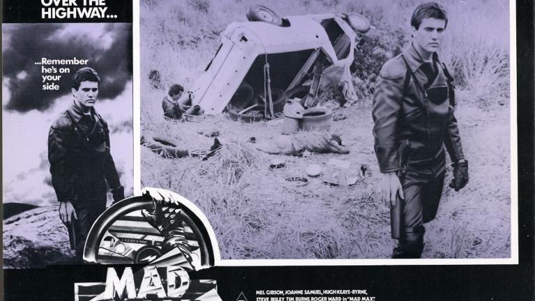 Lobby card for Max Max shows Max (Mel Gibson) next to an overturned car