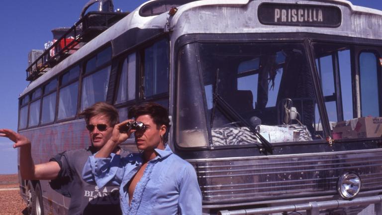 Director Stephan Elliot and Guy Pearce look out across the stony gibber desert with the bus in the background.