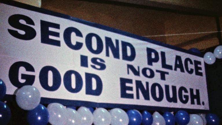 Banner for the Carlton Football Club at the 1970 AFL Grand Final that reads 'Second Place is Not Good Enough'. The banner is surrounded by blue and white balloons.
