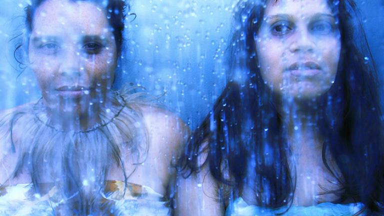 Two women (Nardi Simpson and Kaleena Briggs) standing next to each other, water effect on top.