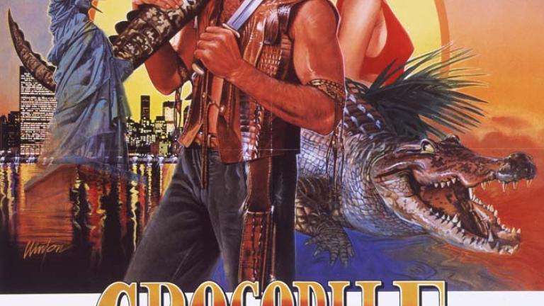 Australian poster for Crocodile Dundee showing illustrations of Mick Dundee, Sue Charlton and a crocodile with the outback and the New York City skyline as backgrounds
