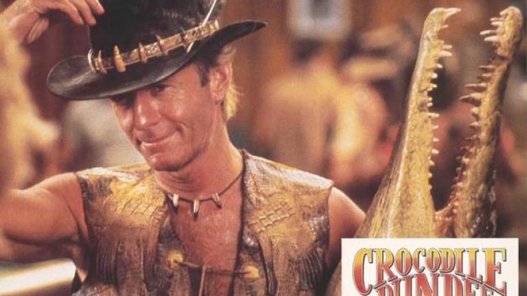 Lobby card showing Paul Hogan as Mick 'Crocodile' Dundee holding a taxidermied crocodile