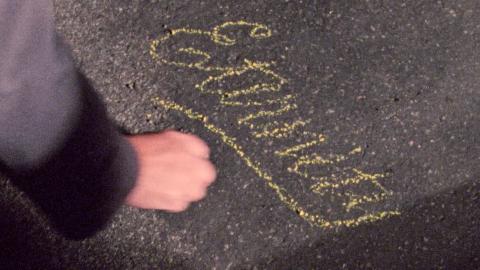 Image of a hand writing 'Eternity' in chalk on the sidewalk