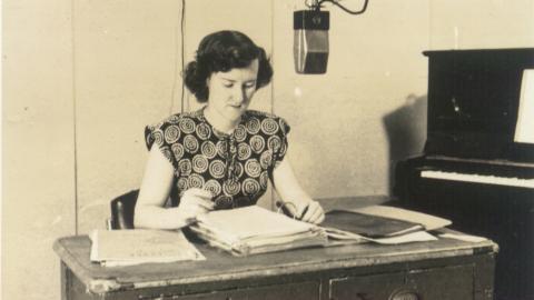Enid Hogan behind a microphone in a radio studio
