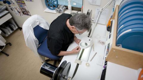 Technician handles film in a lab