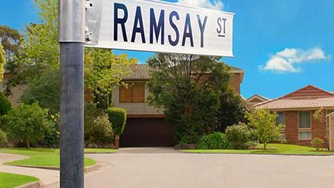 A few houses in a cul-de-sac with a street sign in the foreground that says Ramsay St