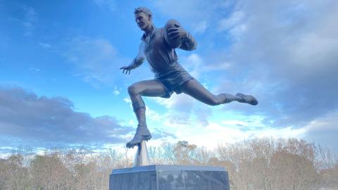 Statue of a man playing Aussie Rules football.