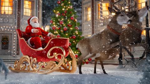 Santa Claus in a sleigh being pulled along by two reindeer in the snow.