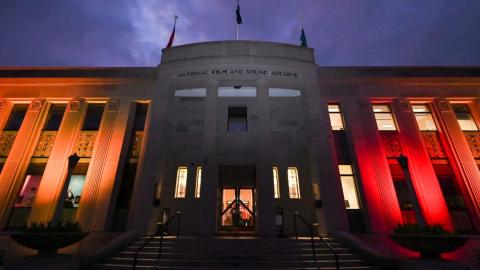 The lighted exterior of the NFSA building in Canberra at night