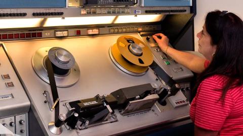 A female staff member works at a tape editing machine at the NFSA