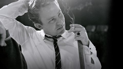 Johnny O'Keefe smoking a cigarette and holding a broom in the TV studio