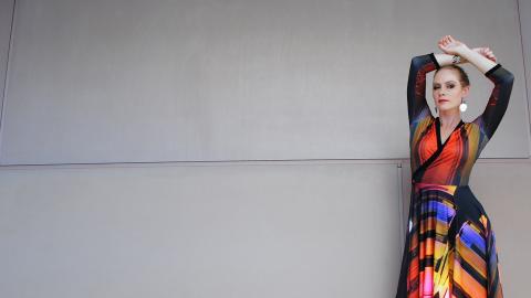Model posing against a wall, wearing Yumi Morrissey's NFSA building dress