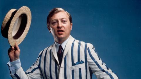 Graham Kennedy wearing a striped jacket and holding a straw boater hat in a promo shot for GTV 9.