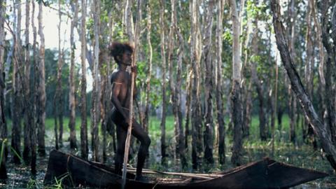 Jamie Gulpilil stands in a canoe in an Arnhem Land swamp