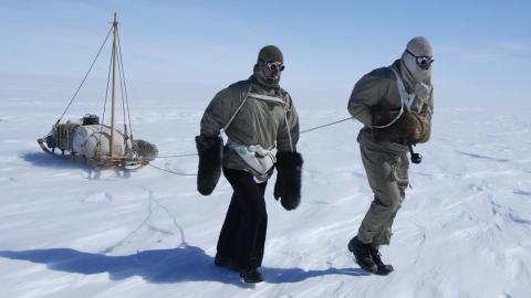 Tim Jarvis and John Stoukala pulling a sledge across the snow in Antarctica for a documentary retracing Mawson's expedition