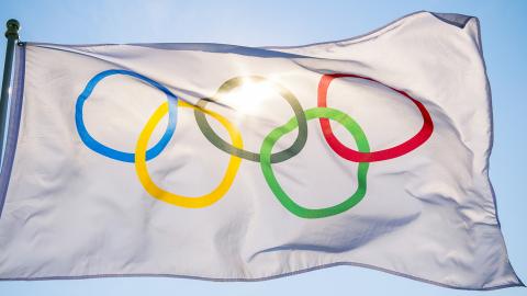 The Olympic flag against a blue sky