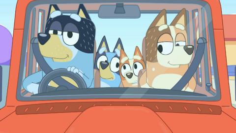 Cartoon of dog parents in a car with their dog children in the back.