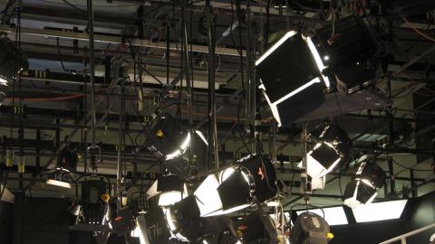 An array of studio lights suspended from the ceiling of a TV studio