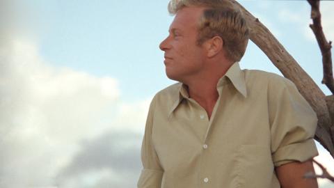 Image of actor Jack Thompson pictured from the chest up, looking sideways, in a still image from the film Sunday Too Far Away.