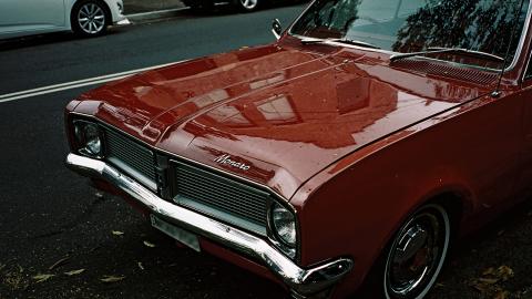 The front grill and bonnet of a red Holden Monaro car.