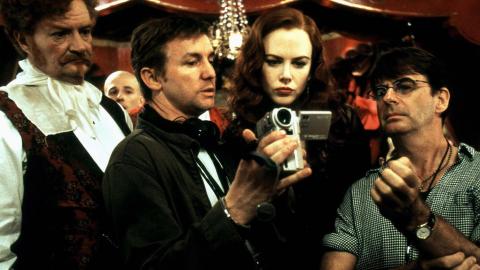 Director Baz Luhrmann with Jin Broadbent and Nicole Kidman looking through a camera viewfinder on the set of Moulin Rouge