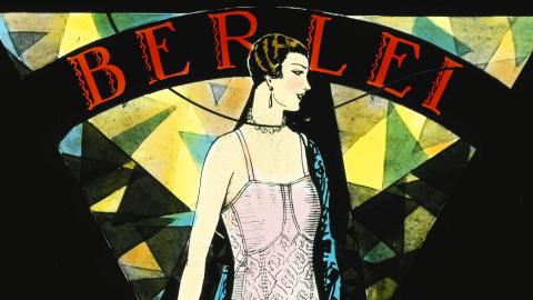 A colour glass slide showing an illustration of a woman wearing a pink Berlei foundation garment with a necklace and earrings. The shapes, font (it says 'berlei') and triangular design elements are influenced by art deco.
